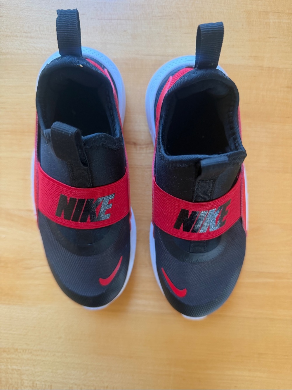 Nike Kids Black Slip-On Sneakers with Red Strap and Swoosh